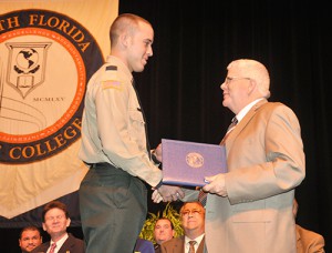 Richard Morey (right), coordinator of South Florida State College’s Criminal Justice programs, presents the “top firearms score” to Brad Webster, third squad leader, for completing 194 out of 203 during the Basic Law Enforcement commencement service on Thursday, Feb. 5, in the SFSC Theatre for the Performing Arts. 