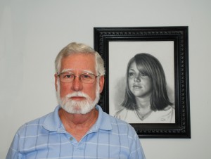 Dr. Christopher McConnell in his office with one of his portrait drawings.