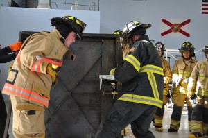 SFSC student Cole Choate wields an axe to breach a metal door in a simulated forced entry.