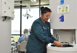 Blanca Cendejas ensuring proper hand hygiene before attending to a patient at SFSC’s dental education clinic.