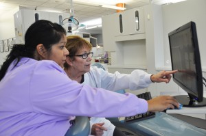 Darlene Saccuzzo (right) with an SFSC dental hygiene student reviewing X-rays in the SFSC Dental Education clinic.