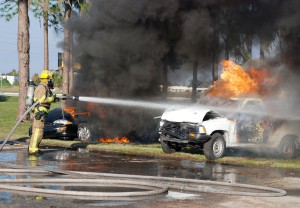 A firefighter extinguishes an automobile fire in a class offered by the Great Florida Fire School.