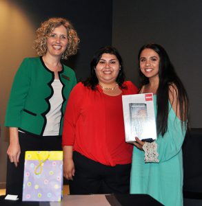 Jamie Bateman, mentor Danielle Ochoa, and Take Stock graduate Rosie Fimbres, who show the laptop computer she won.