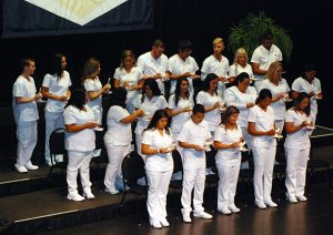 Graduates lighting lanterns during the candle lighting ceremony