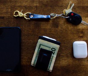 Photo of wallet, keys, phone, ear buds