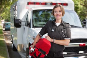 Portrait of a happy paramedica carrying a portable oxygen unit