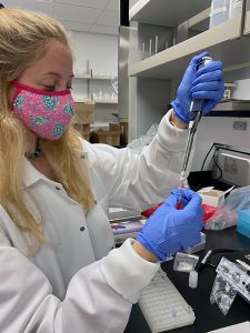 Rimoldi Ibanez working in the lab with gloves and a mask on