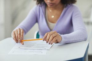 Female student holding a pencil and taking a test.