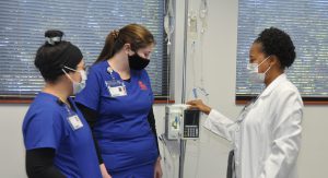 Nursing students and nursing instructor looking over equipment
