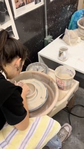 Student on wheel in Pottery class