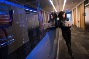 Woman holding a laptop next to a NOC.