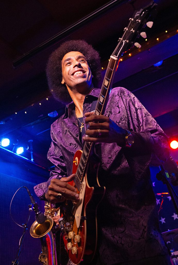 Selwyn Birchwood with guitar and sax