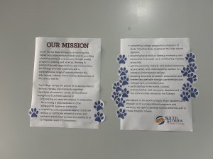 Two posters with paw print stickers all over them.