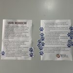 Two posters with paw print stickers all over them.