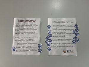 Two posters with paw print stickers all over them.