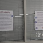 Two posters with paw print stickers all over them.