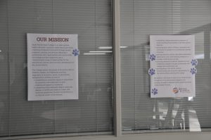 Two posters with paw print stickers all over them.