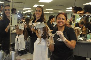 Cosmetology students practicing on mannequins.