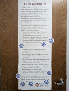 Two posters with paw print stickers all over them.