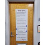 Two posters with paw print stickers all over them.