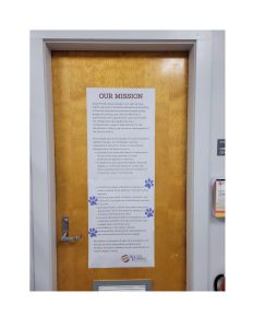 Two posters with paw print stickers all over them.